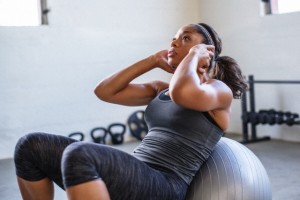 Fit woman doing situps on fitness ball