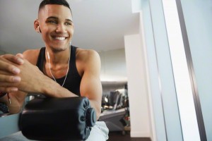 Black man smiling on exercise machine in gym