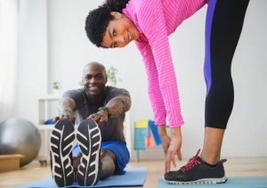 Couple stretching in gym